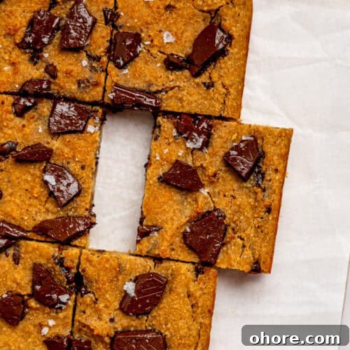 Gooey Chickpea Cookie Bars — Protein-Packed Dessert Bars 10 Bird's eye view of healthy cookie bars on a sheet of white parchment paper.