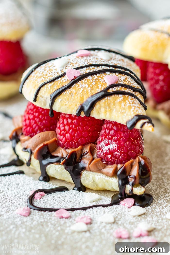 Flaky Puff Pastry Hearts for Valentine’s Day Gifts 2 Valentine's Day puff pastry heart filled with raspberries, chocolate cream and drizzled with chocolate sauce, topped with powdered sugar and heart-shaped sprinkles.