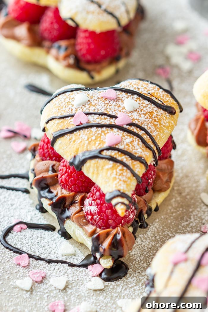 Flaky Puff Pastry Hearts for Valentine’s Day Gifts 7 Heart-shaped puff pastry with raspberries, chocolate cream, powdered sugar and chocolate drizzle.