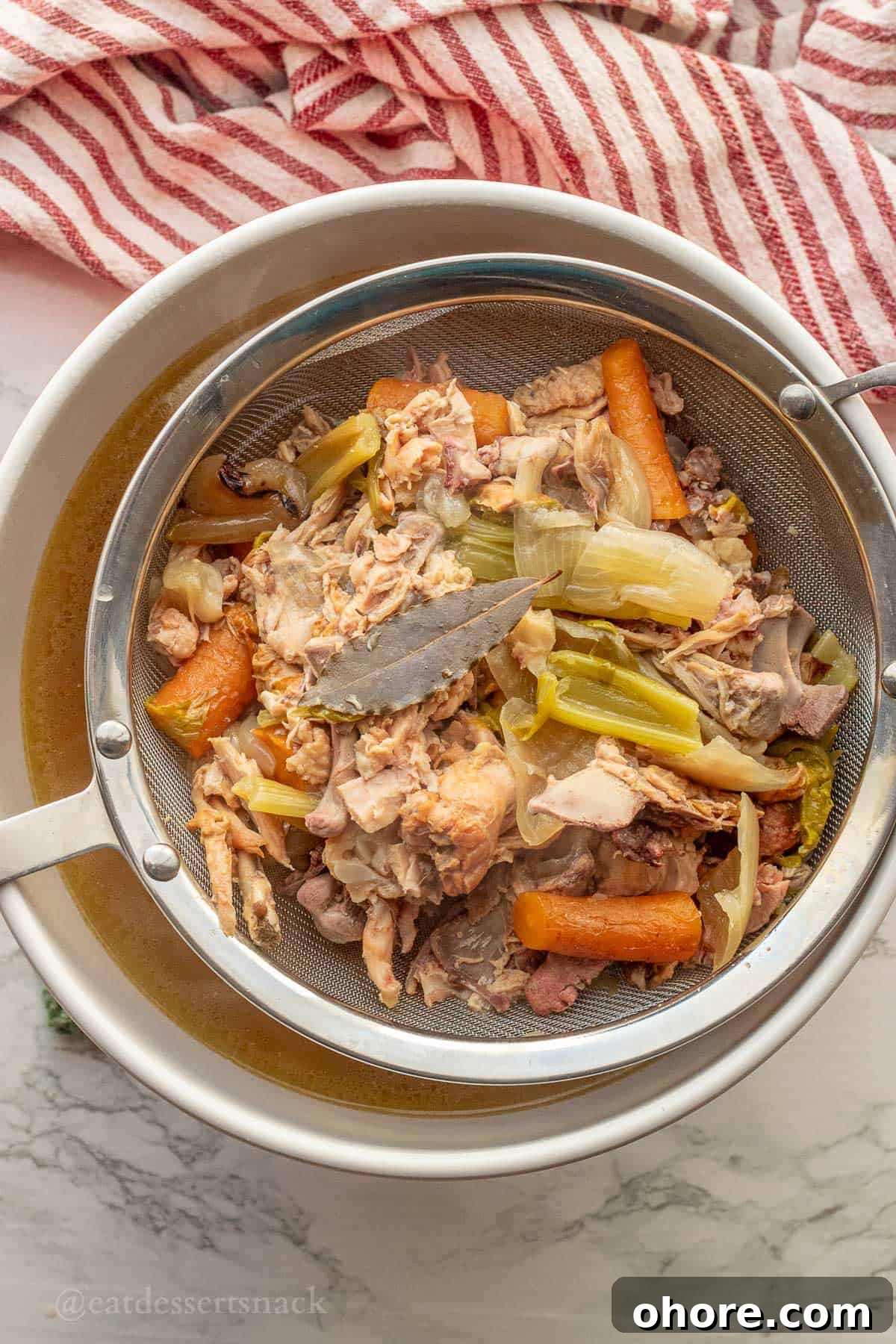 Homemade Instant Pot Chicken Bone Broth Recipe 9 Cooked vegetables in mesh strainer.