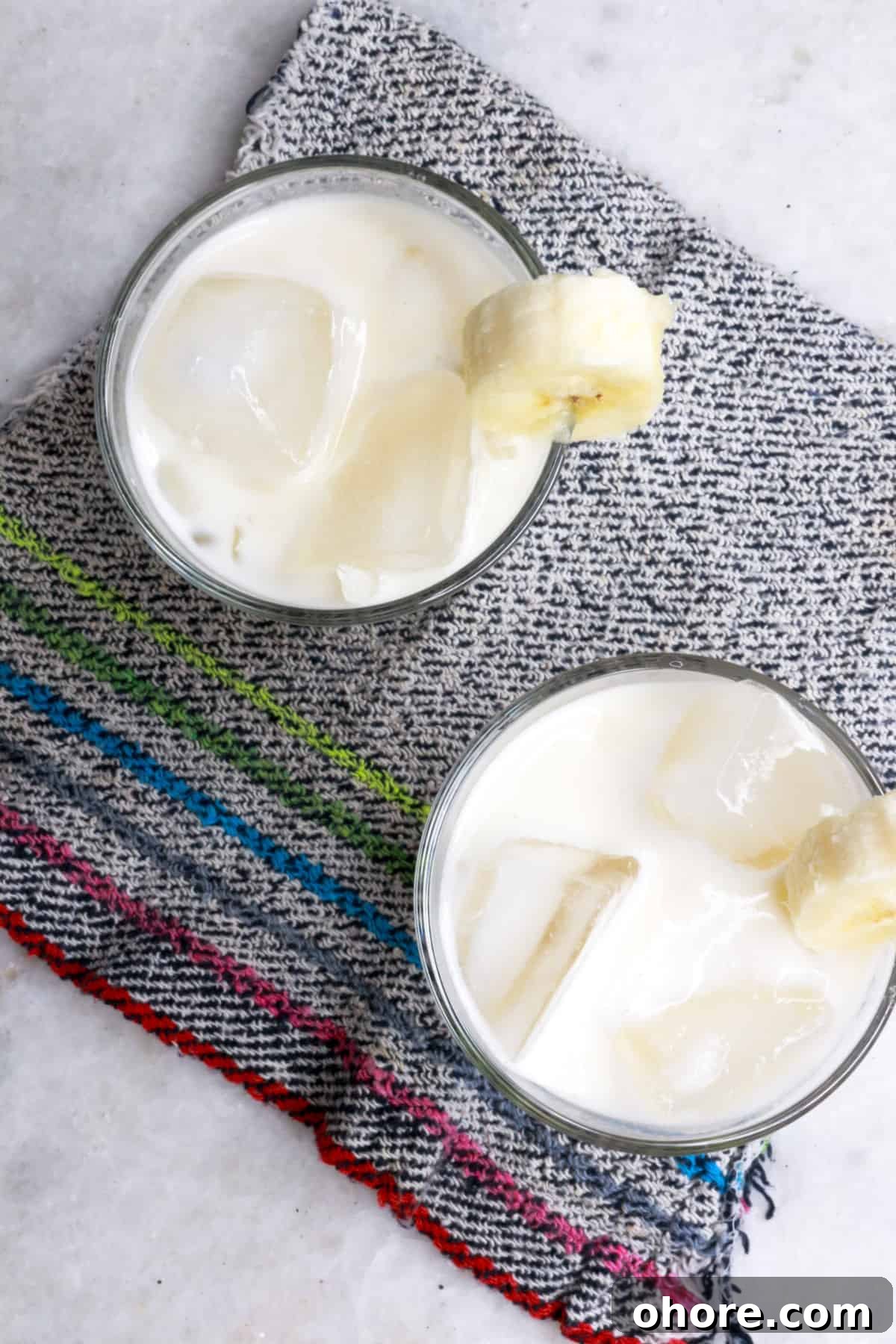 Banana Agua Fresca Recipe — Refreshing Banana Water Drink 7 Overhead view of 2 glasses with creamy banana agua fresca