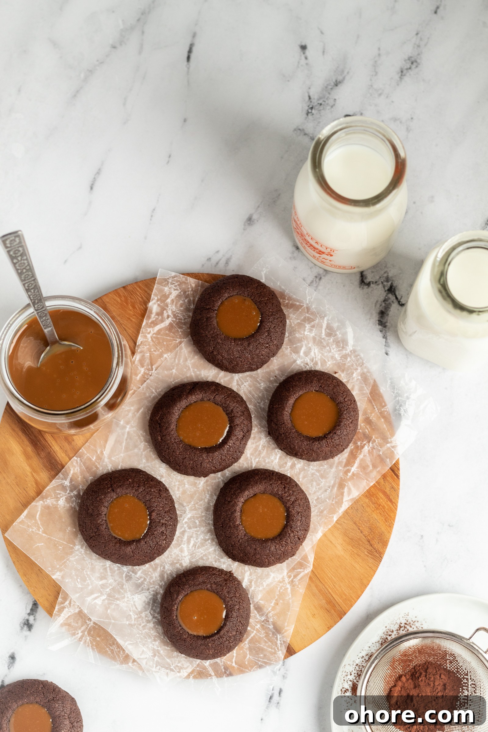 Chewy Dulce de Leche Sandwich Cookies 3 A batch of chocolate cookies, a jar of dulce de leche and some milk jugs.