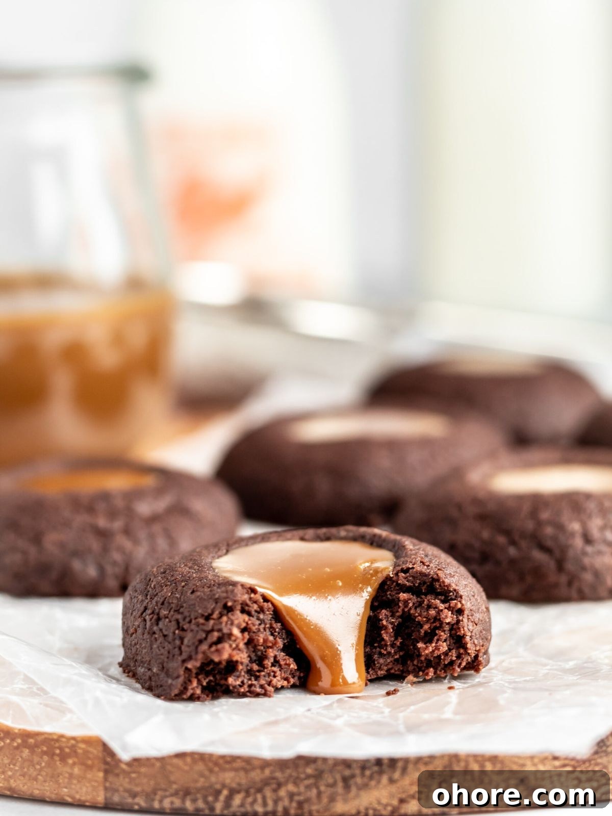 Chewy Dulce de Leche Sandwich Cookies 5 A chocolate thumbprint filled with dulce de leche with a bite taken out of it.