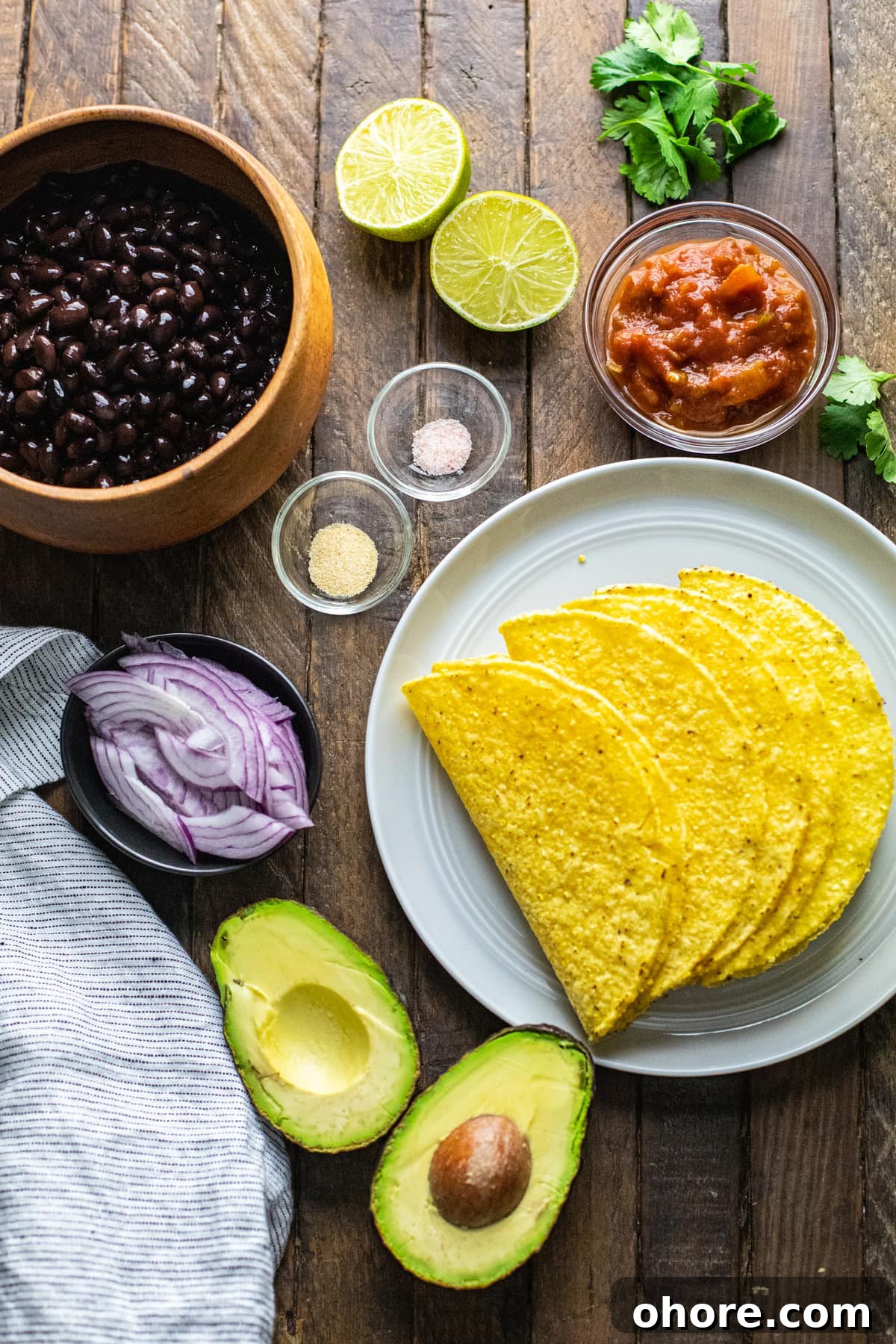 Quick Black Bean Tacos Ready in 10 Minutes 3 Ingredients for black bean tacos arranged on wooden background.