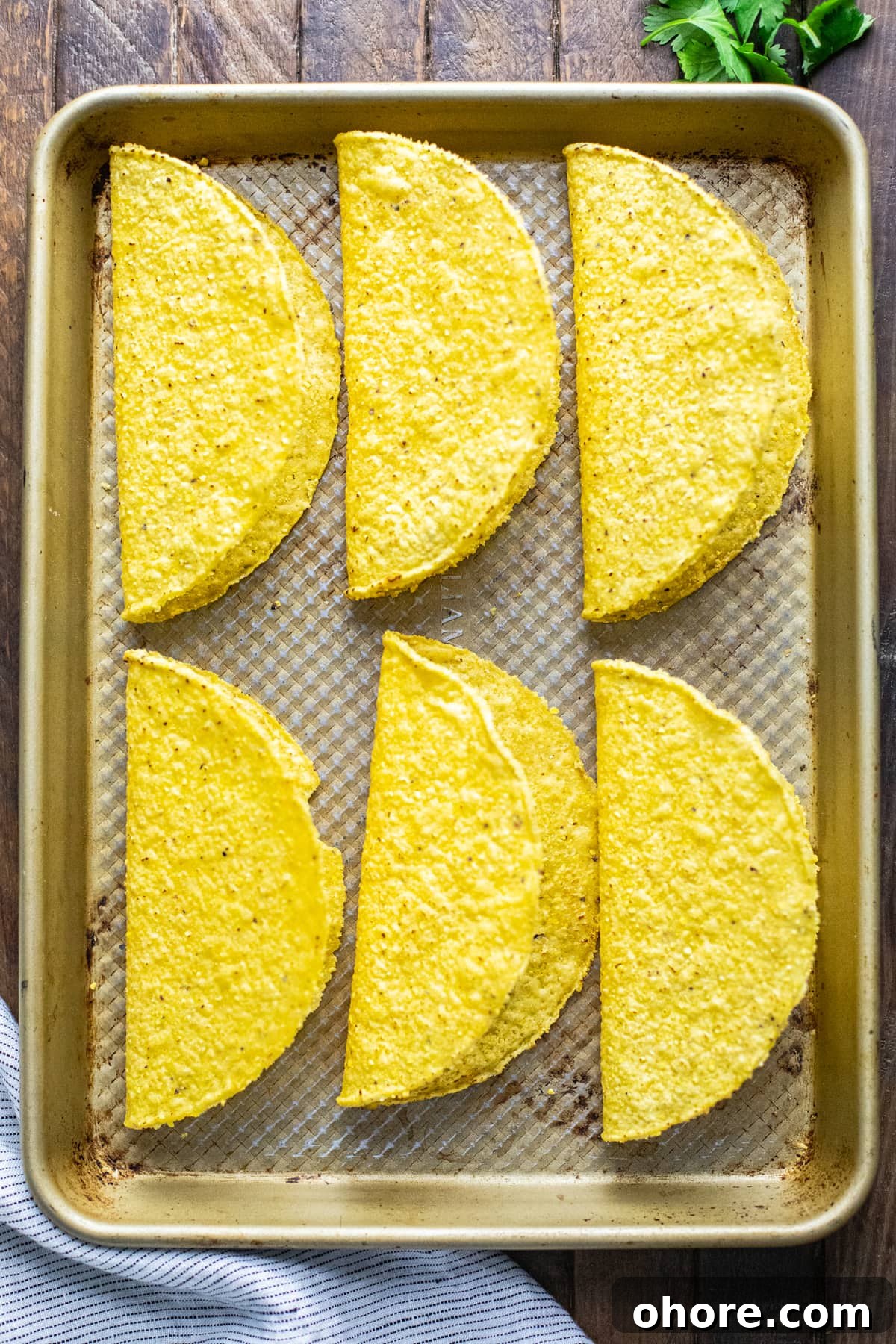 Quick Black Bean Tacos Ready in 10 Minutes 5 hardshell tortillas on a baking sheet pan.