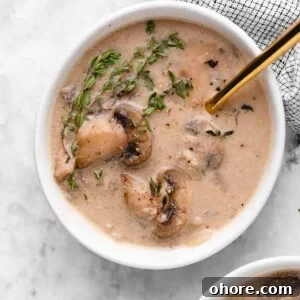 Overhead shot of mushroom soup with a gold spoon