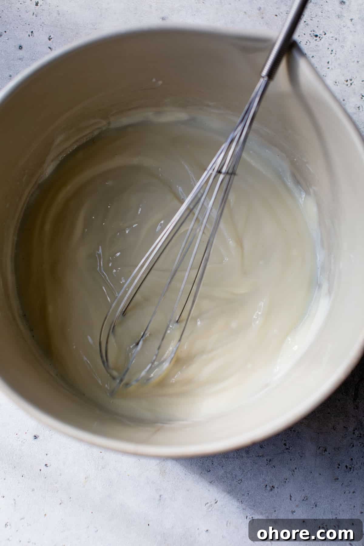 Creamy Greek Yogurt Fruit Salad with Honey and Mint 3 yogurt dressing whisked together in a bowl