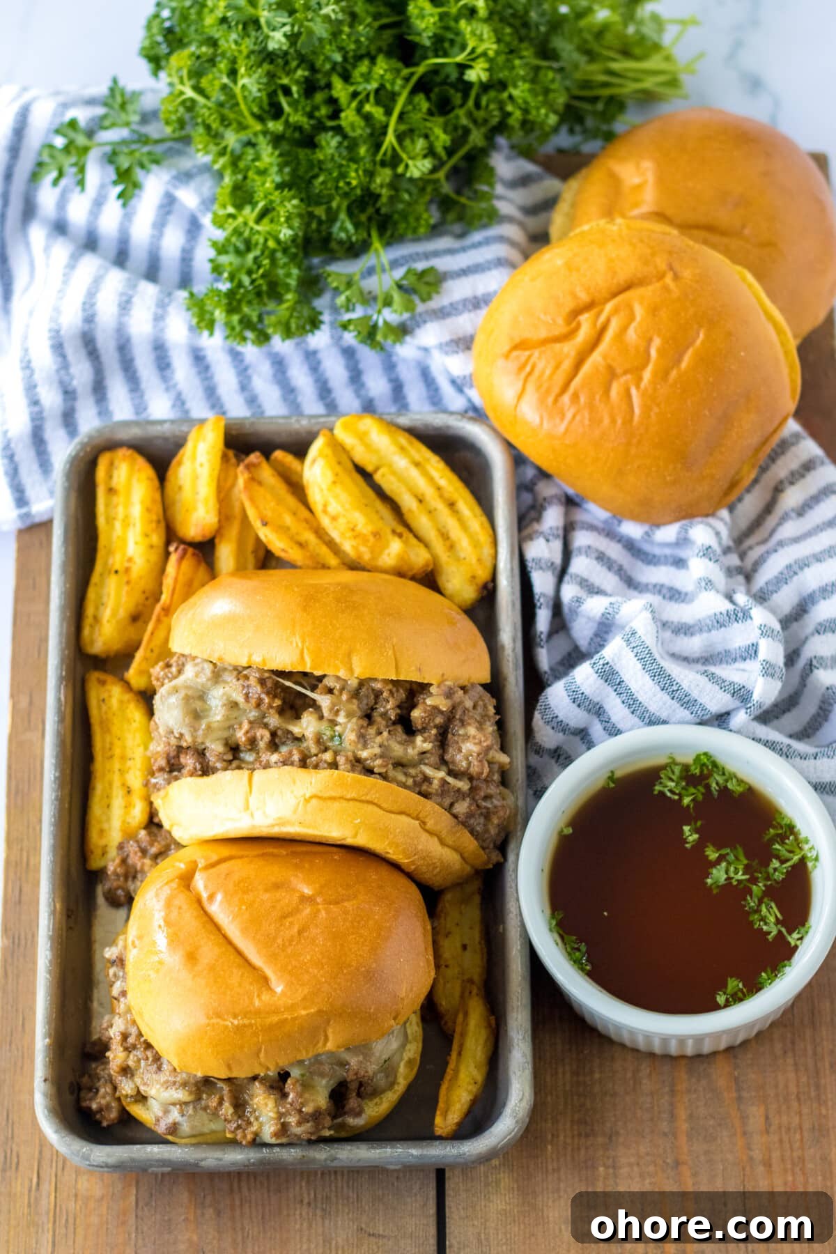 French Onion Sloppy Joes on a blue striped table cloth.