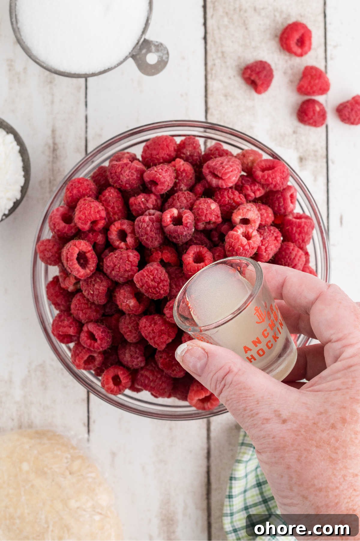 Homemade Raspberry Pie Recipe: Flaky Crust & Fresh Filling 4 A bowl of fresh raspberries having lemon juice poured over.