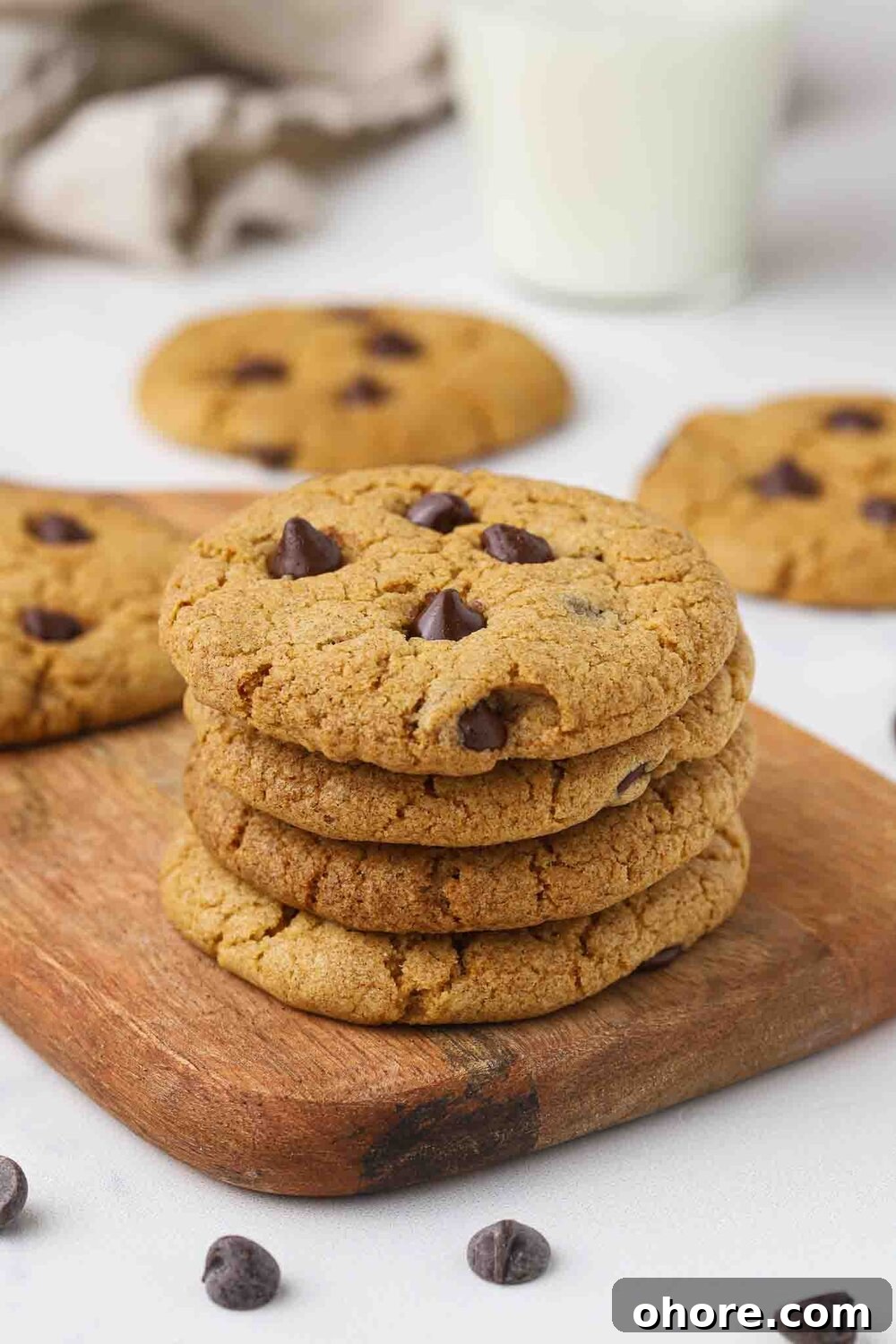 Stack of chocolate chip cookies on a cutting board.