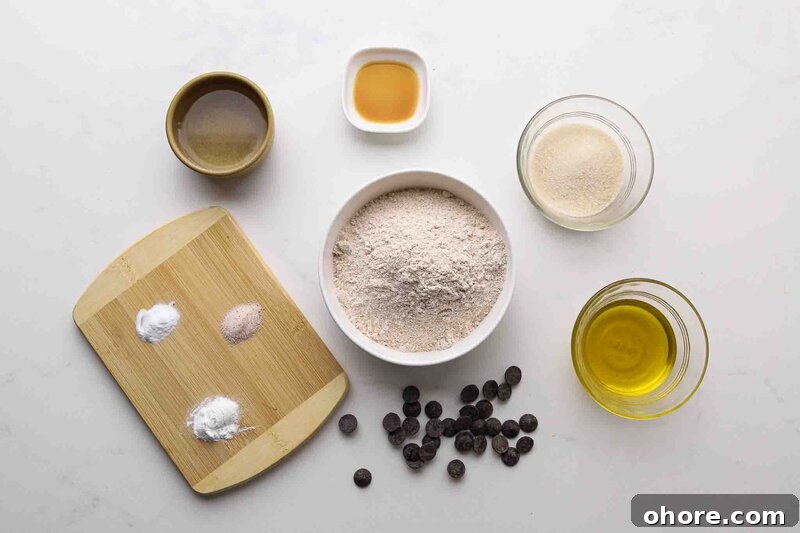 Flour, baking powder, baking soda, salt, sugar, and olive oil on a table.
