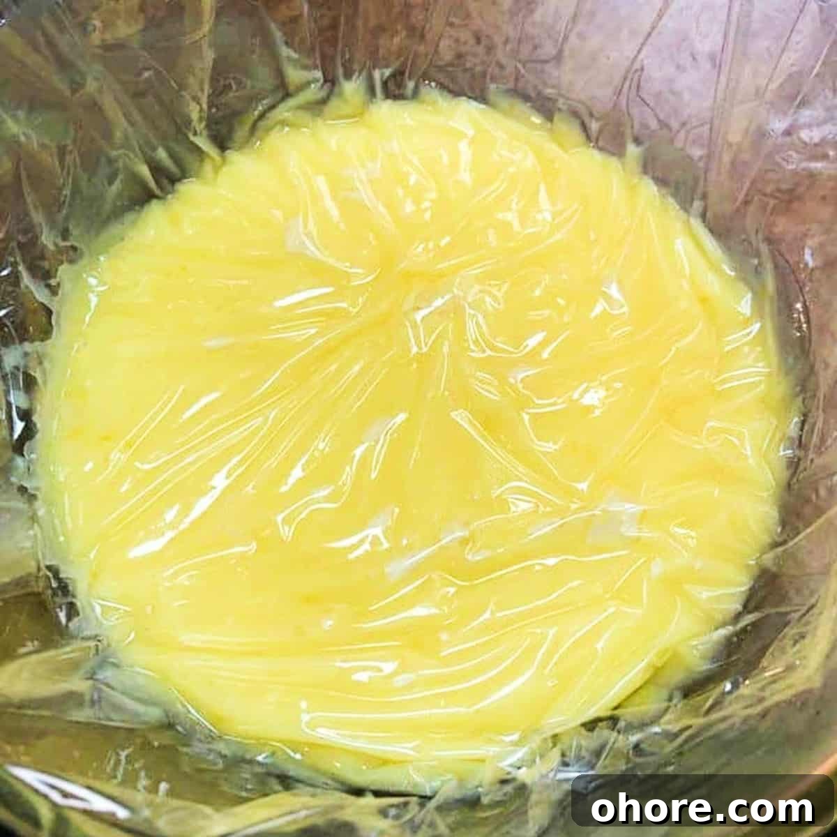 Homemade Meyer Lemon Curd Recipe — Bright Citrus Spread 7 lemon curd covered in plastic wrap to prevent film.