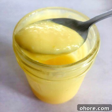 Homemade Meyer Lemon Curd Recipe — Bright Citrus Spread 9 homemade lemon curd in a jar with a spoon
