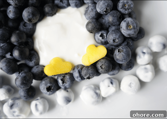 close up shot of blueberries with yogurt and mango with feet cut out with flower cookie cutter