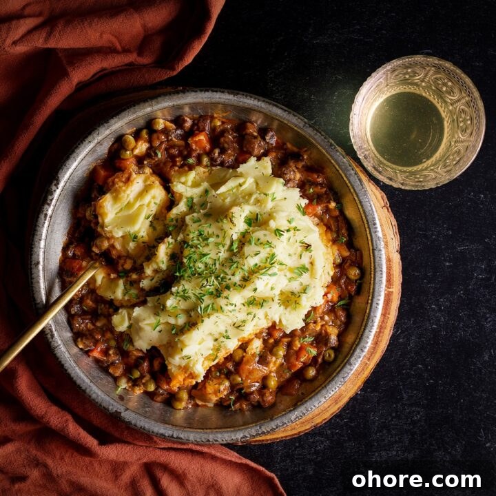 A plate filled with vegetarian shepherds pie with cream cheese mashed potatoes.