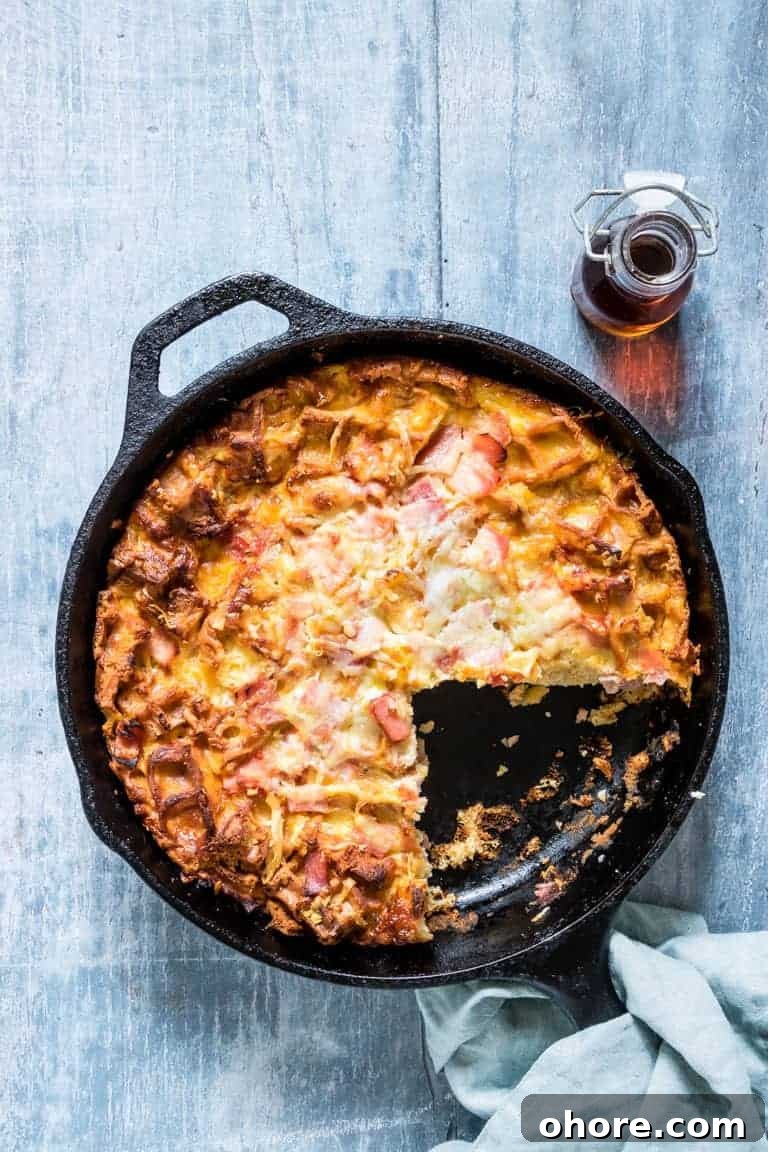 Festive Christmas Casserole Recipes for Holiday Gatherings 3 Cheesy Waffle and Ham Breakfast Casserole in the skillet with one serving removed