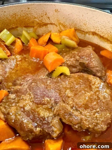 A Dutch oven of tender pot roast with vegetables.