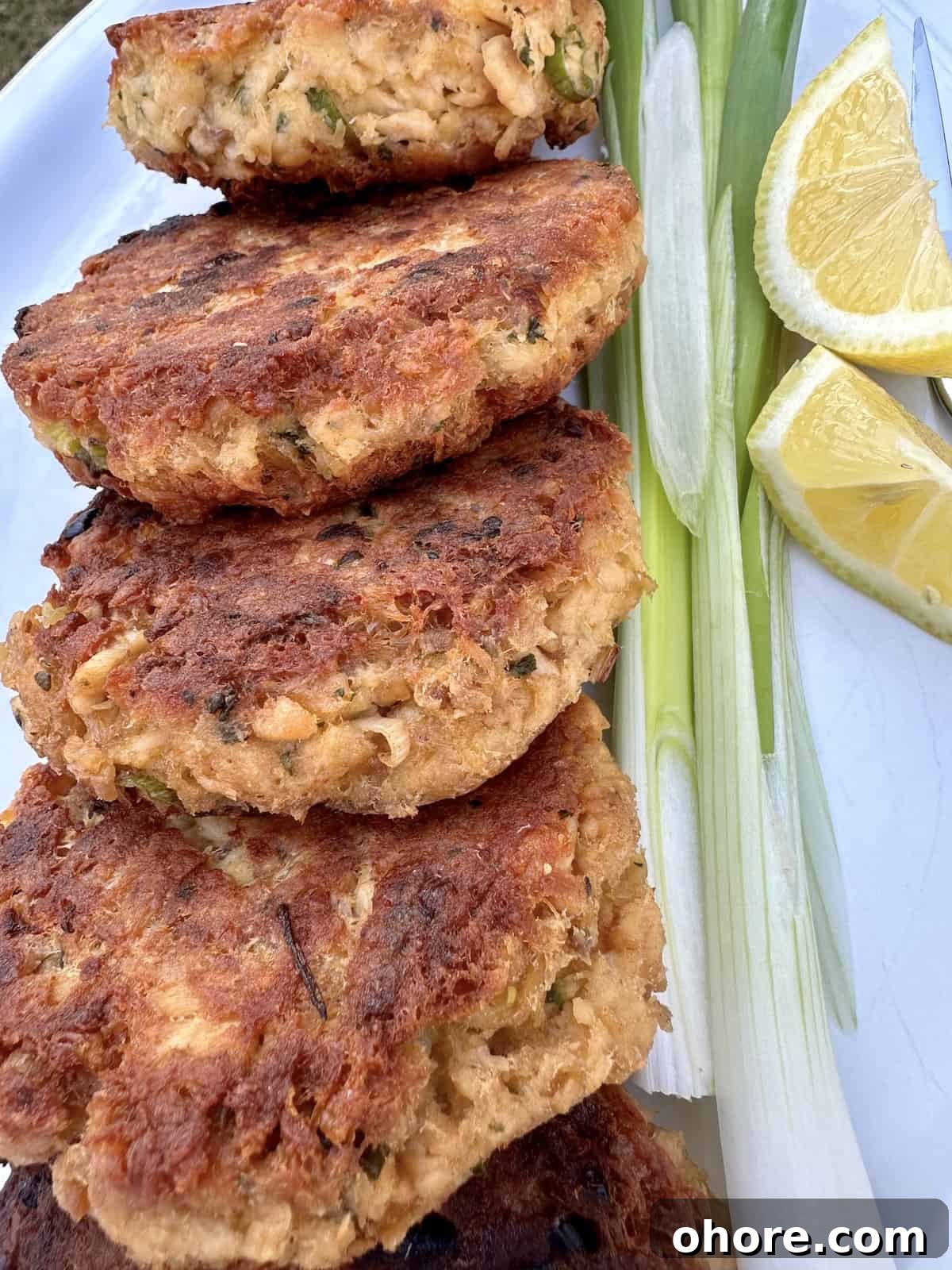 Cooked salmon patties on a plate with garnishes.