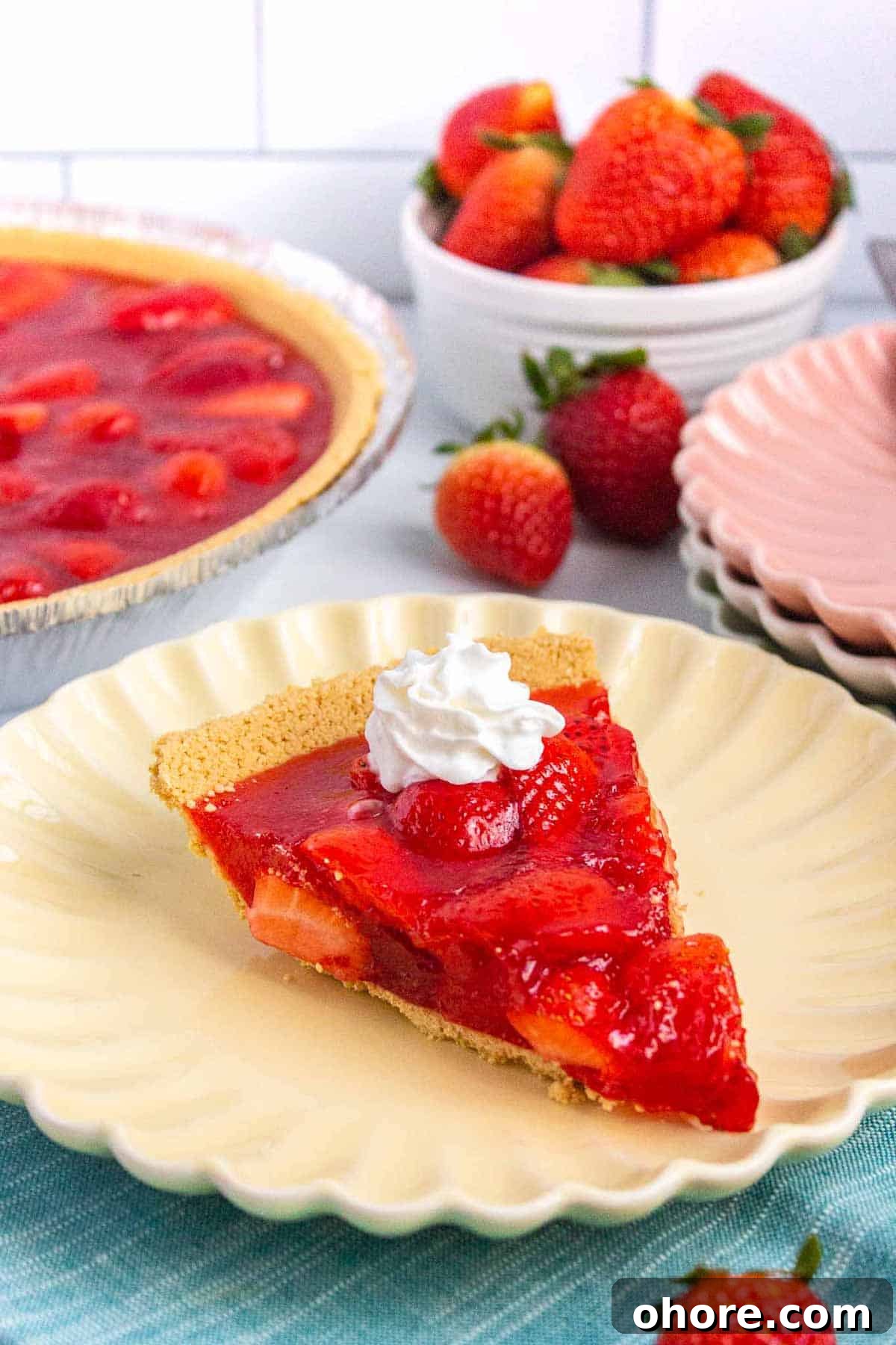 Slice of strawberry jello pie topped with a dollop of whipped cream.