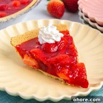 Slice of strawberry jello pie with a dollop of whipped topping