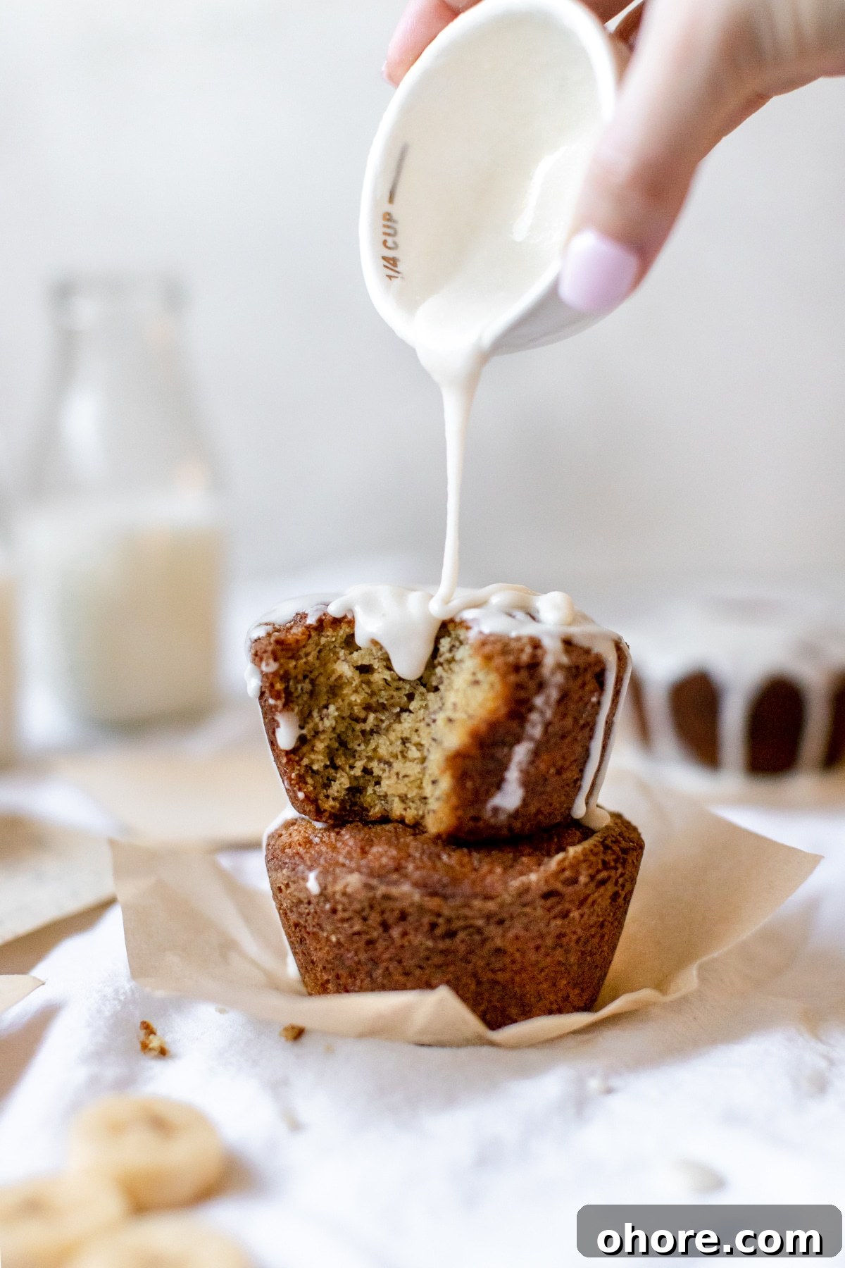 Spiced Rum Banana Muffins with a Boozy Twist 3 frosting being poured on muffins