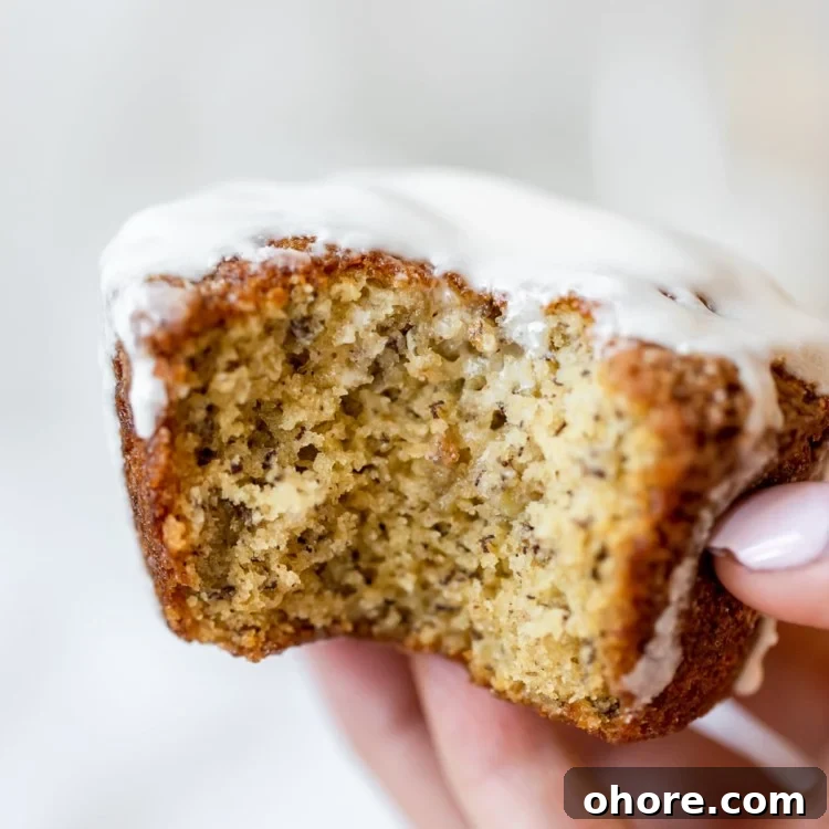 Spiced Rum Banana Muffins with a Boozy Twist 6 a womans hand holding a muffin