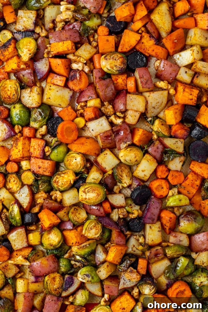 Honey-Roasted Vegetables with Miso Glaze and Crunchy Walnuts 2 sweet potatoes, carrots, red potato, brussels sprouts and walnuts on a sheet pan with honey butter glaze