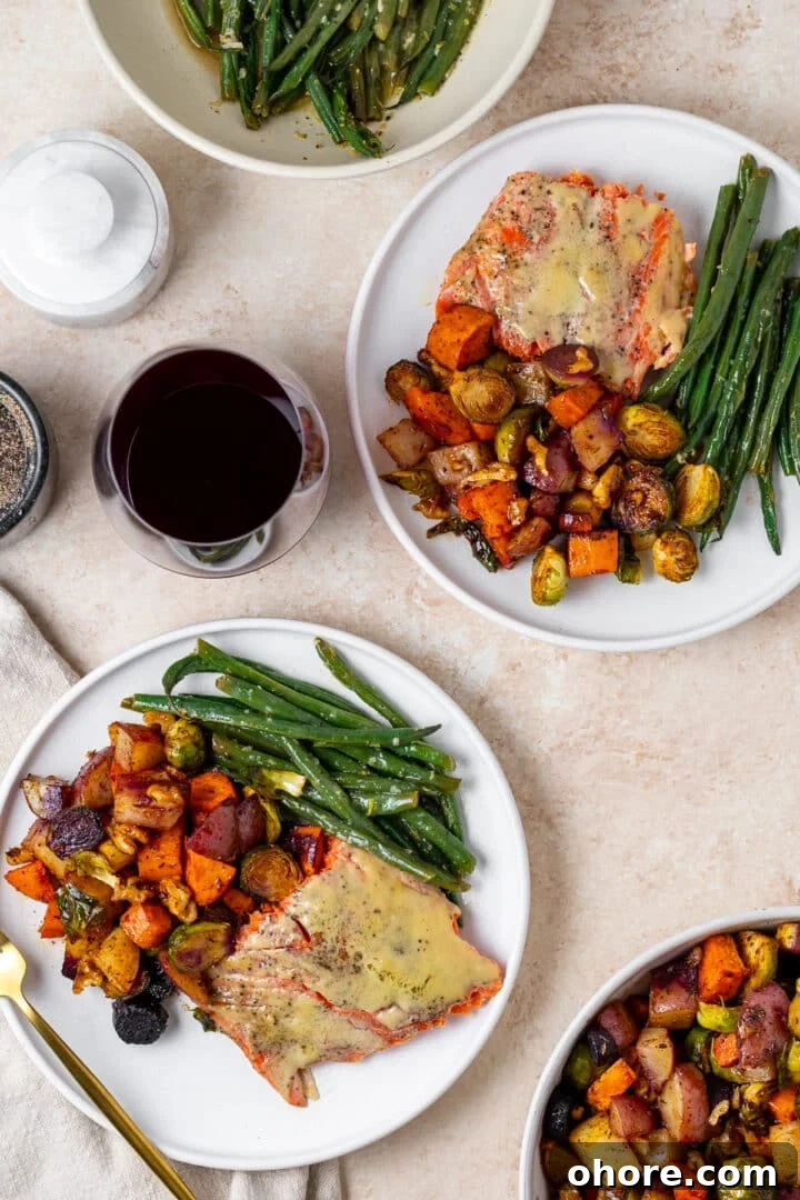 Honey-Roasted Vegetables with Miso Glaze and Crunchy Walnuts 11 two white plates with green beans, roasted veggies and salmon, glass of red wine, gold fork