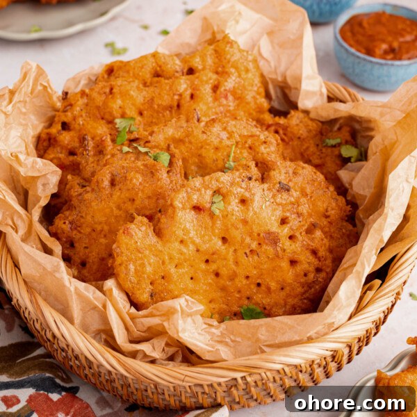 A basket filled with bacalaitos (or codfish fritters) sits on a countertop with napkins.