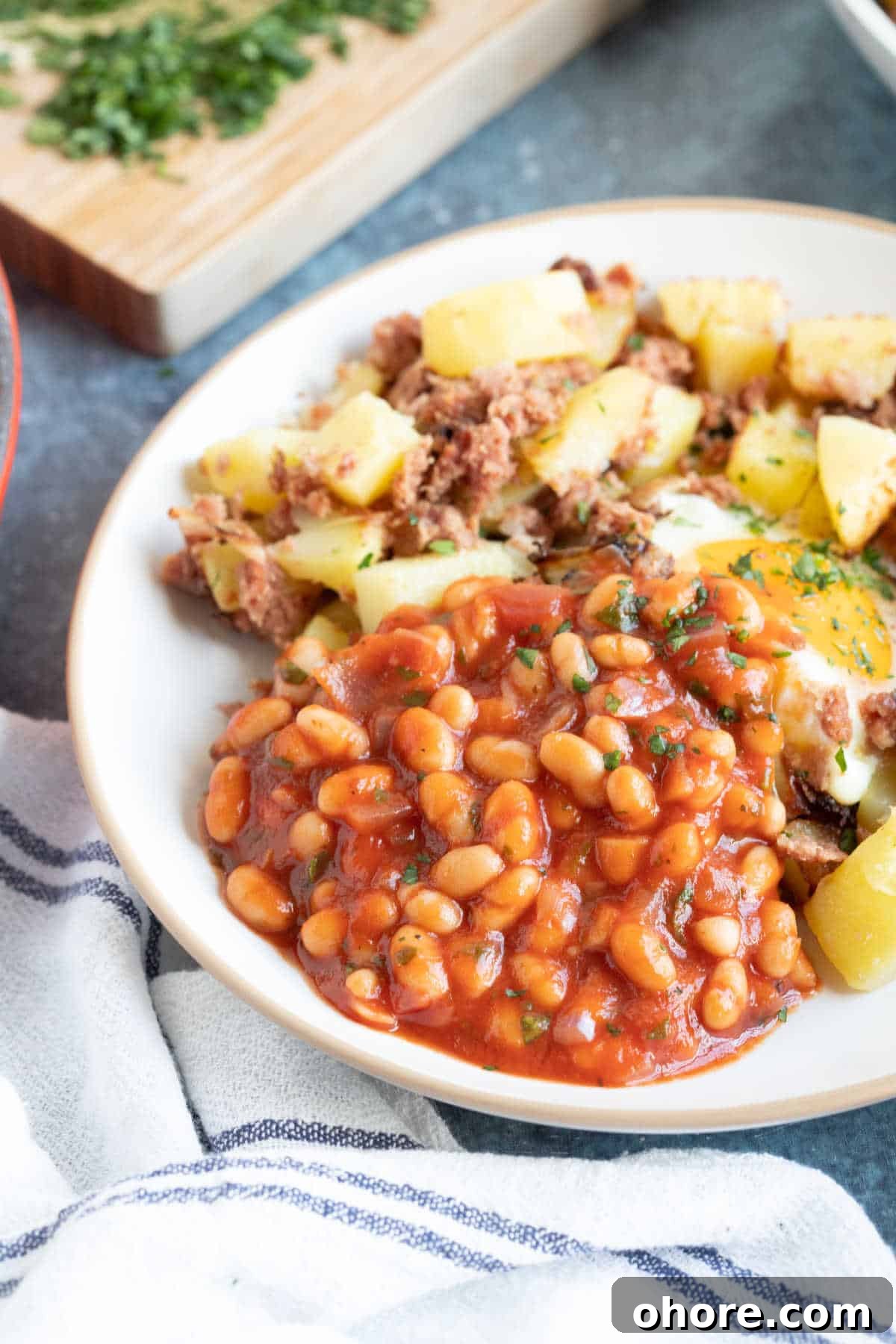Authentic Homemade British Baked Beans Recipe for Breakfast 6 A plate of baked beans, fried egg, and potatoes.