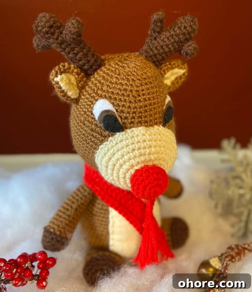 Free Rudolph the Red-Nosed Reindeer Crochet Pattern Guide 4 Doll sitting in fluffy white cotton, looking like snow.