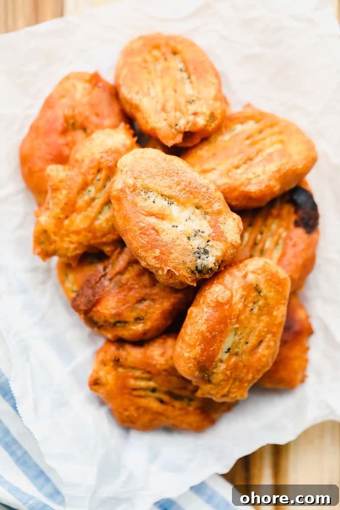 Crispy Beer-Battered Vegan Fish Fillets 8 piles of golden brown vegan fried fish on a piece of white parchment paper