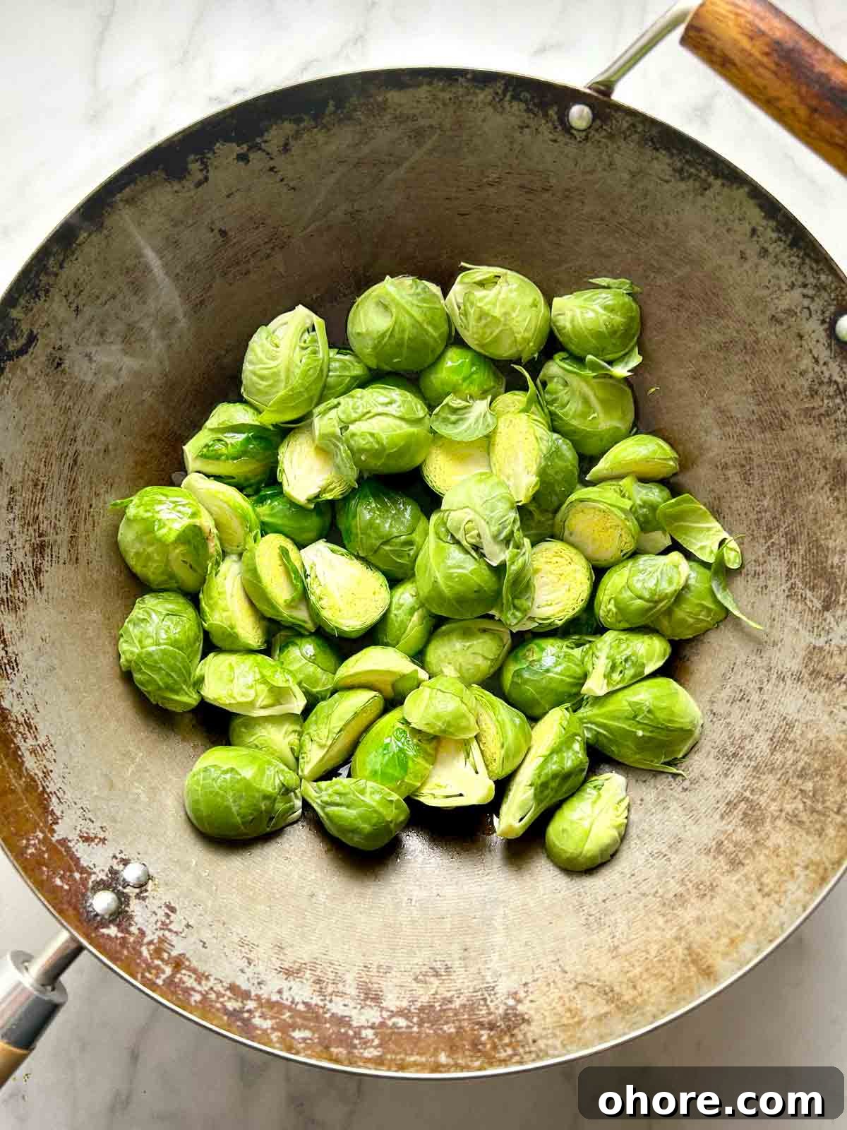 PF Chang's-Style Kung Pao Brussels Sprouts Recipe 5 raw Brussels sprouts in wok.