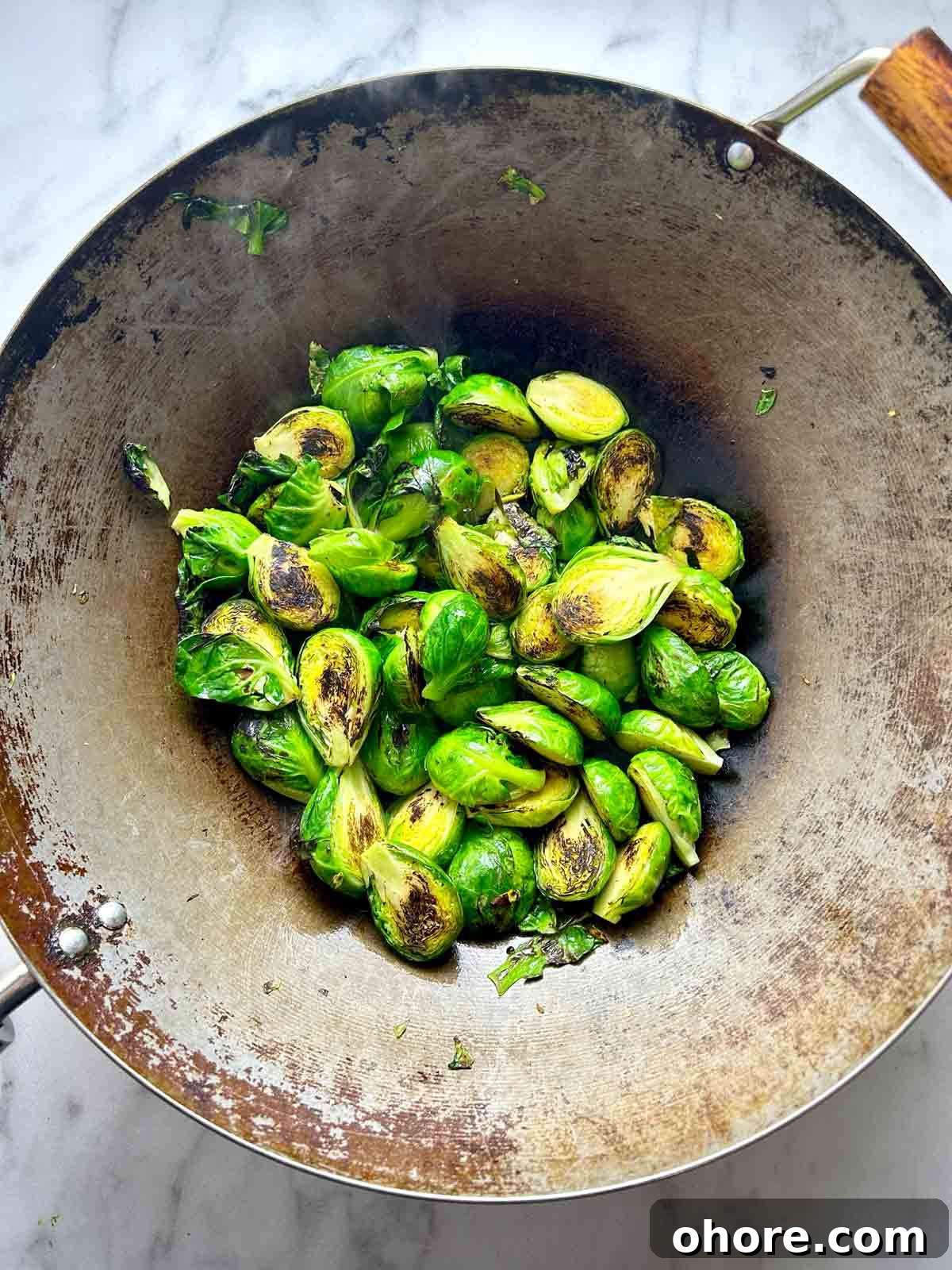 PF Chang's-Style Kung Pao Brussels Sprouts Recipe 6 charred Brussels sprouts in wok.