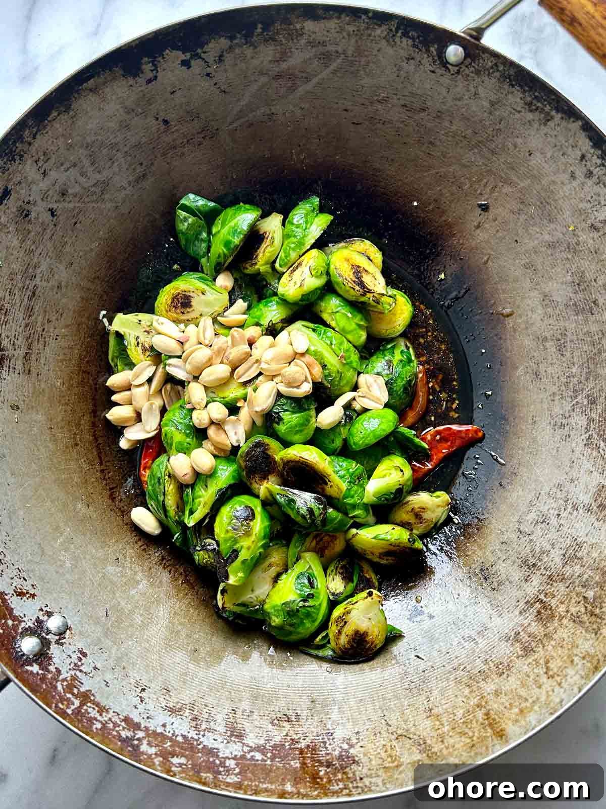 PF Chang's-Style Kung Pao Brussels Sprouts Recipe 9 peanuts and Brussels sprouts added to wok.