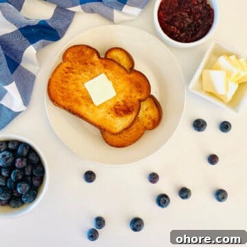 air fryer toast on plate with a slice of butter, next to jam and butter