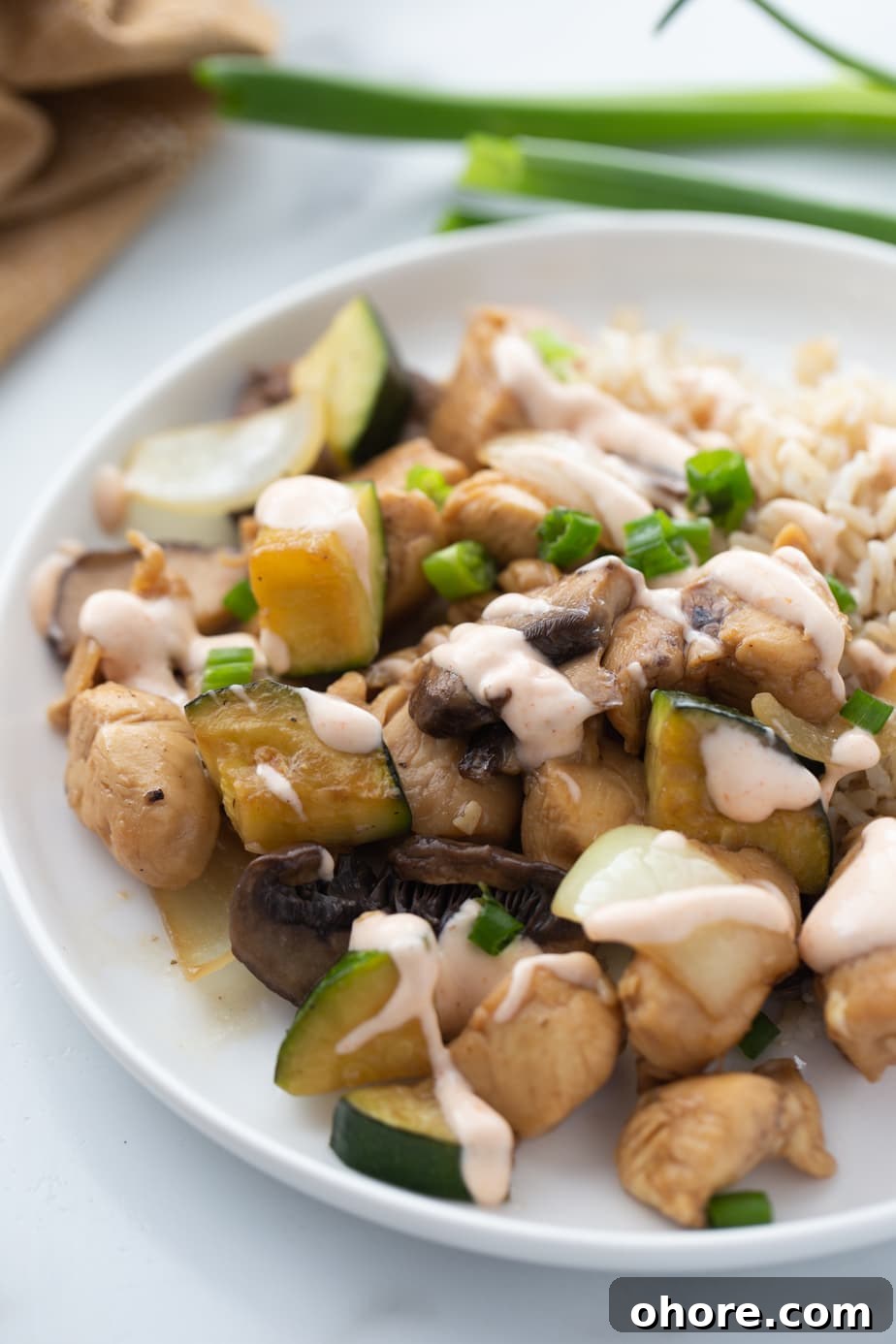 Hibachi Chicken Recipe: Tender Grilled Chicken with Garlic Butter 2 A white plate contains a serving of hibachi style chicken, veggies and rice.