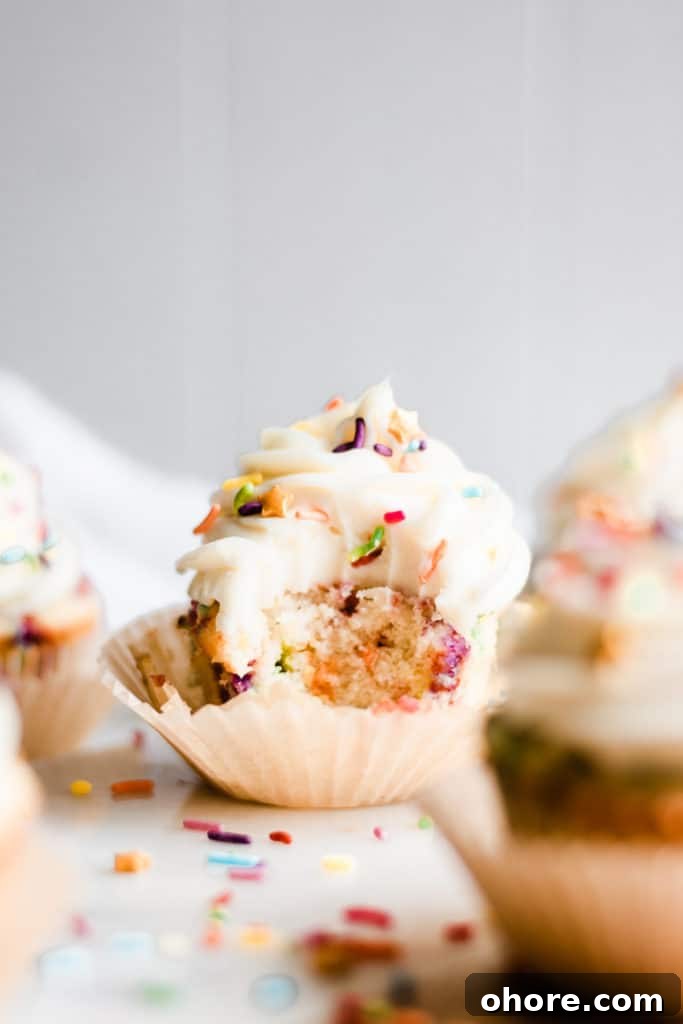 A Funfetti cupcake with bite missing.