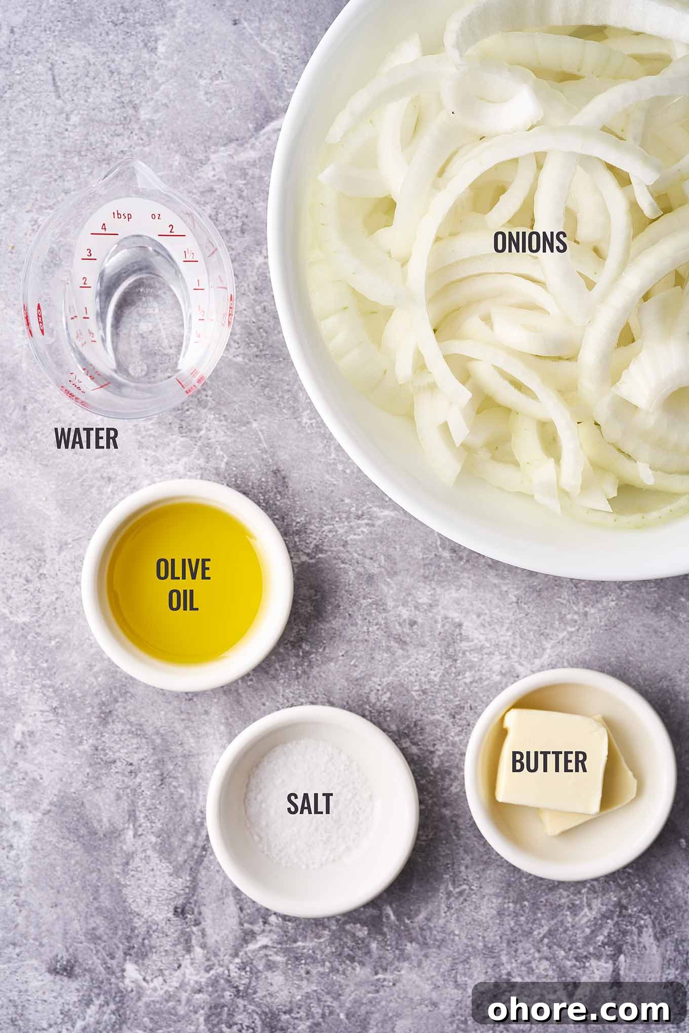 Perfect Caramelized Onions: Simple Step-by-Step Recipe 3 A labeled, overhead photo of the ingredients needed to make caramelized onions; sliced onions, olive oil, butter, salt, and water.