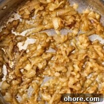 Perfect Caramelized Onions: Simple Step-by-Step Recipe 6 A stainless steel skillet filled with perfectly caramelized onions.