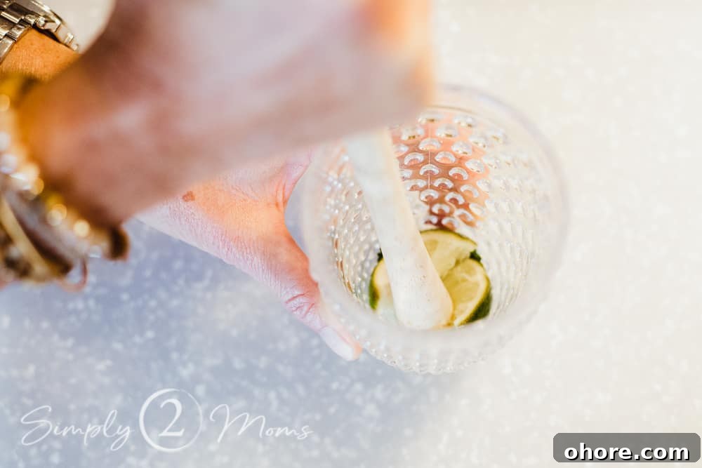 photo of someone muddling fresh lime and mint to make a mojito