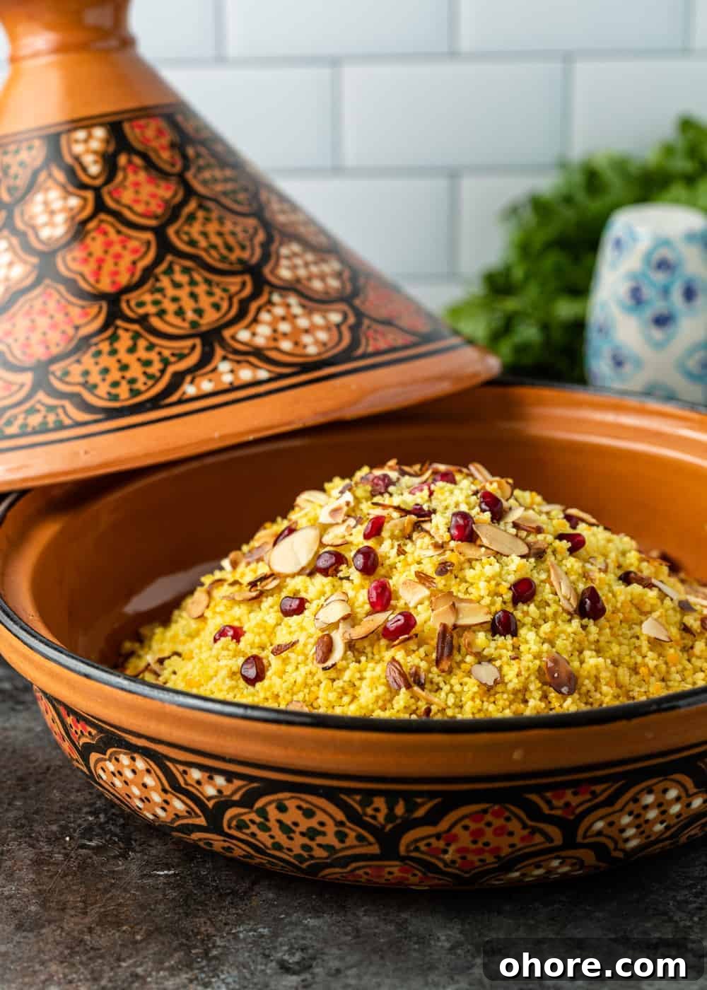 side view: a tagine filled with yellow pearled moroccan couscous