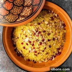 couscous with pomegranate arils and almonds in a tagine with a decorative lid