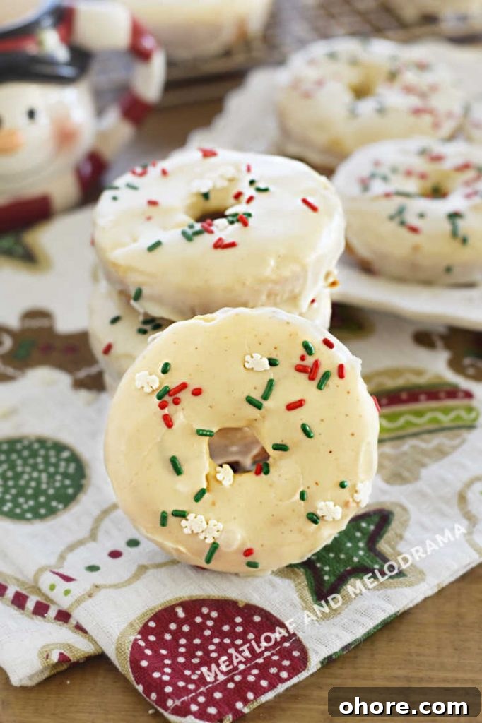 eggnog donuts topped with eggnog glaze and red and green sprinkles on table