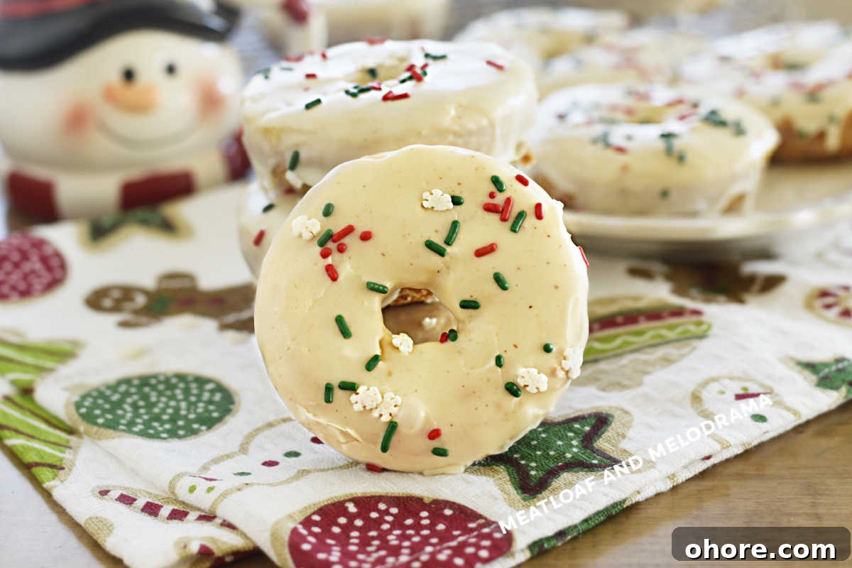 baked eggnog donuts with glaze and red and green sprinkles on the table