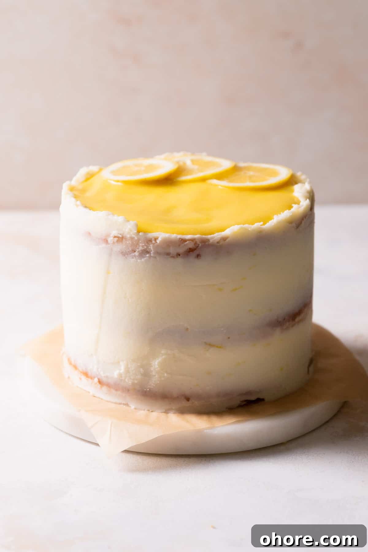 Zesty Lemon Bar Cake Recipe with Tender Shortbread Crust 13 the decorated lemon bar cake on a white marble slab.