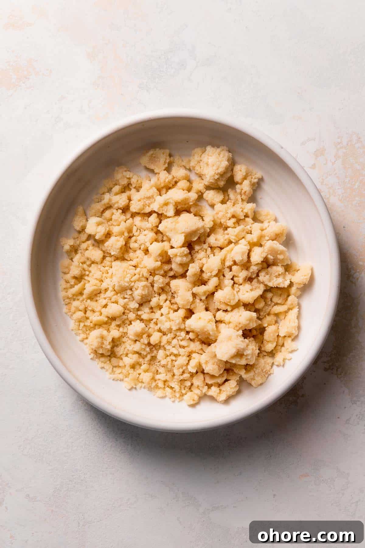 Zesty Lemon Bar Cake Recipe with Tender Shortbread Crust 5 shortbread crumbs in a white bowl.