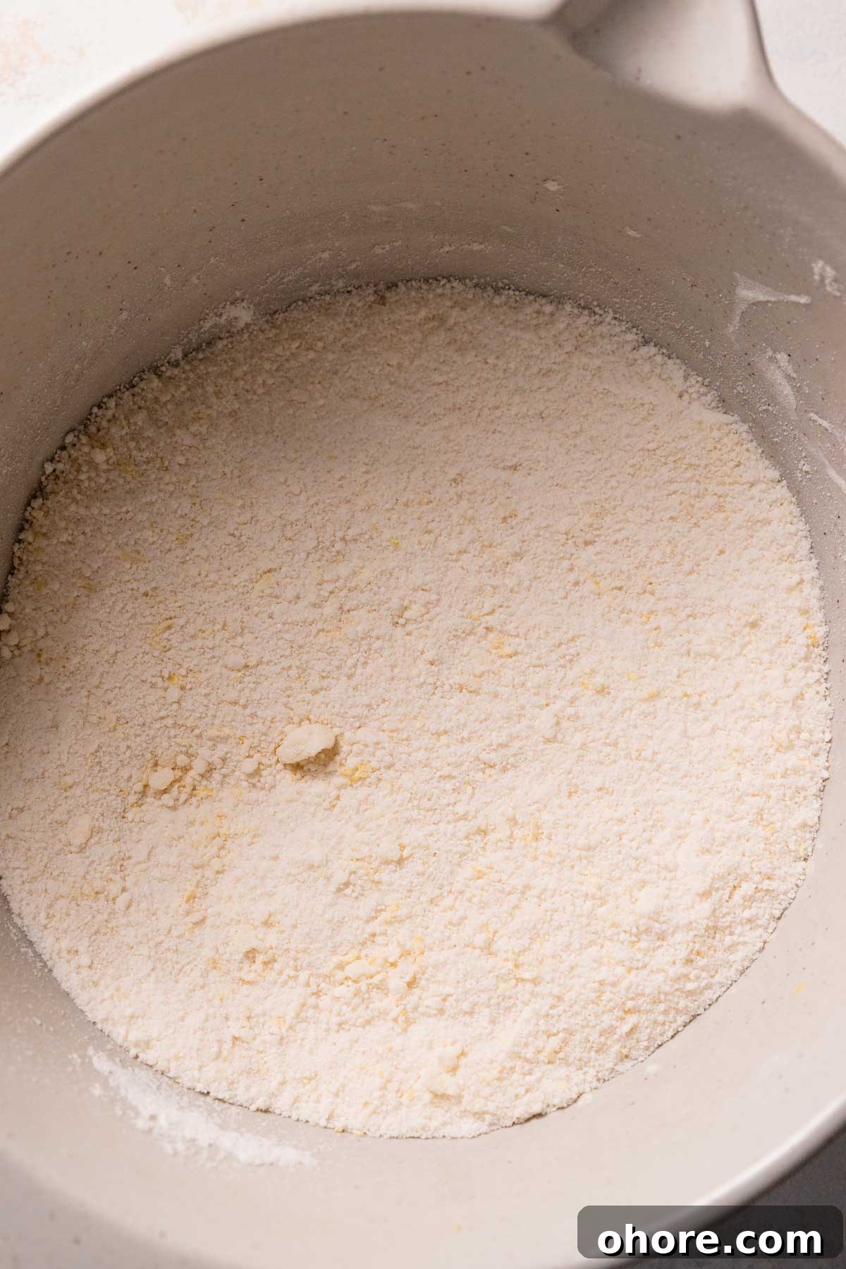 Zesty Lemon Bar Cake Recipe with Tender Shortbread Crust 7 dry ingredients and butter mixed together in a mixing bowl.