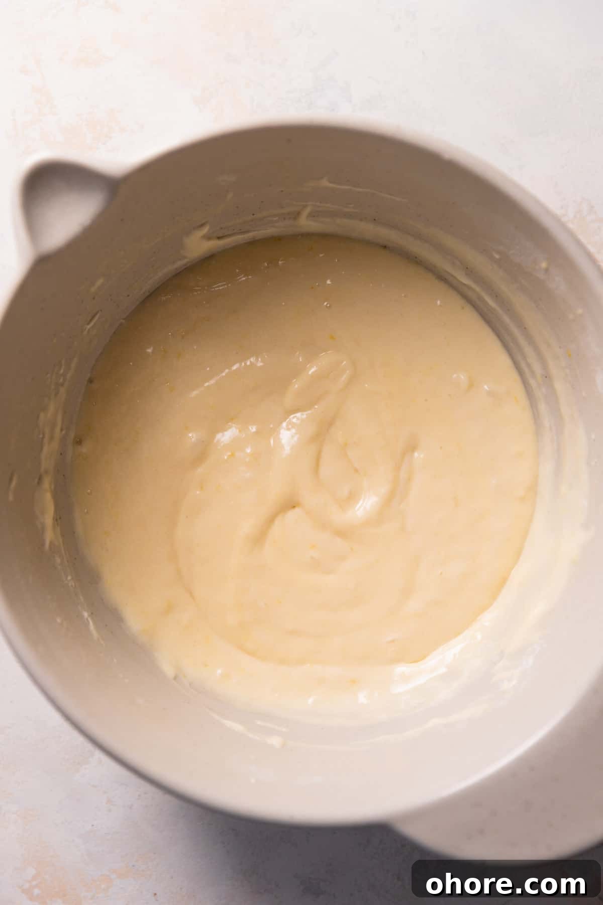 Zesty Lemon Bar Cake Recipe with Tender Shortbread Crust 9 lemon cake batter in a mixing bowl.