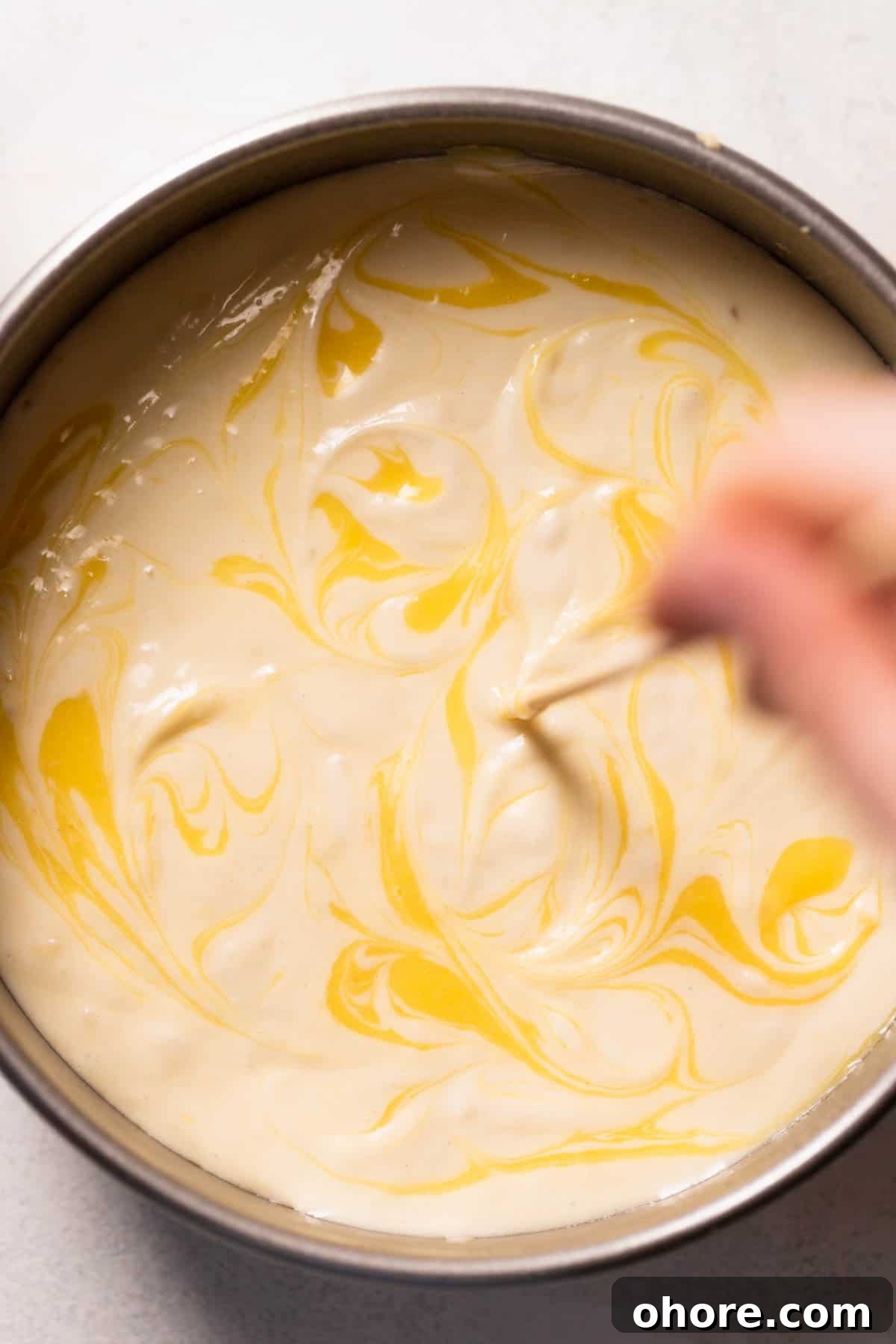 Zesty Lemon Bar Cake Recipe with Tender Shortbread Crust 10 a toothpick swirling lemon curd into the cake batter.